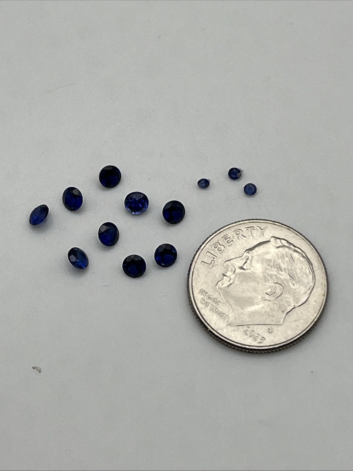Nine 3 Mm And Three 1.5 Mm Round Faceted Synthetic Blue Sapphires