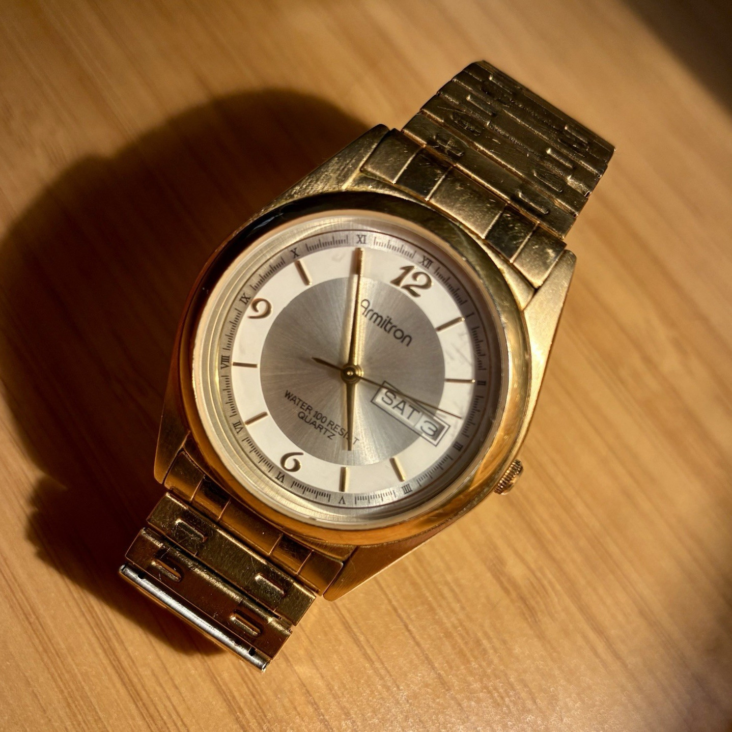 Armitron Men’s Quartz Day/Date 100m Gold-Tone Wristwatch Silver Sunburst Dial