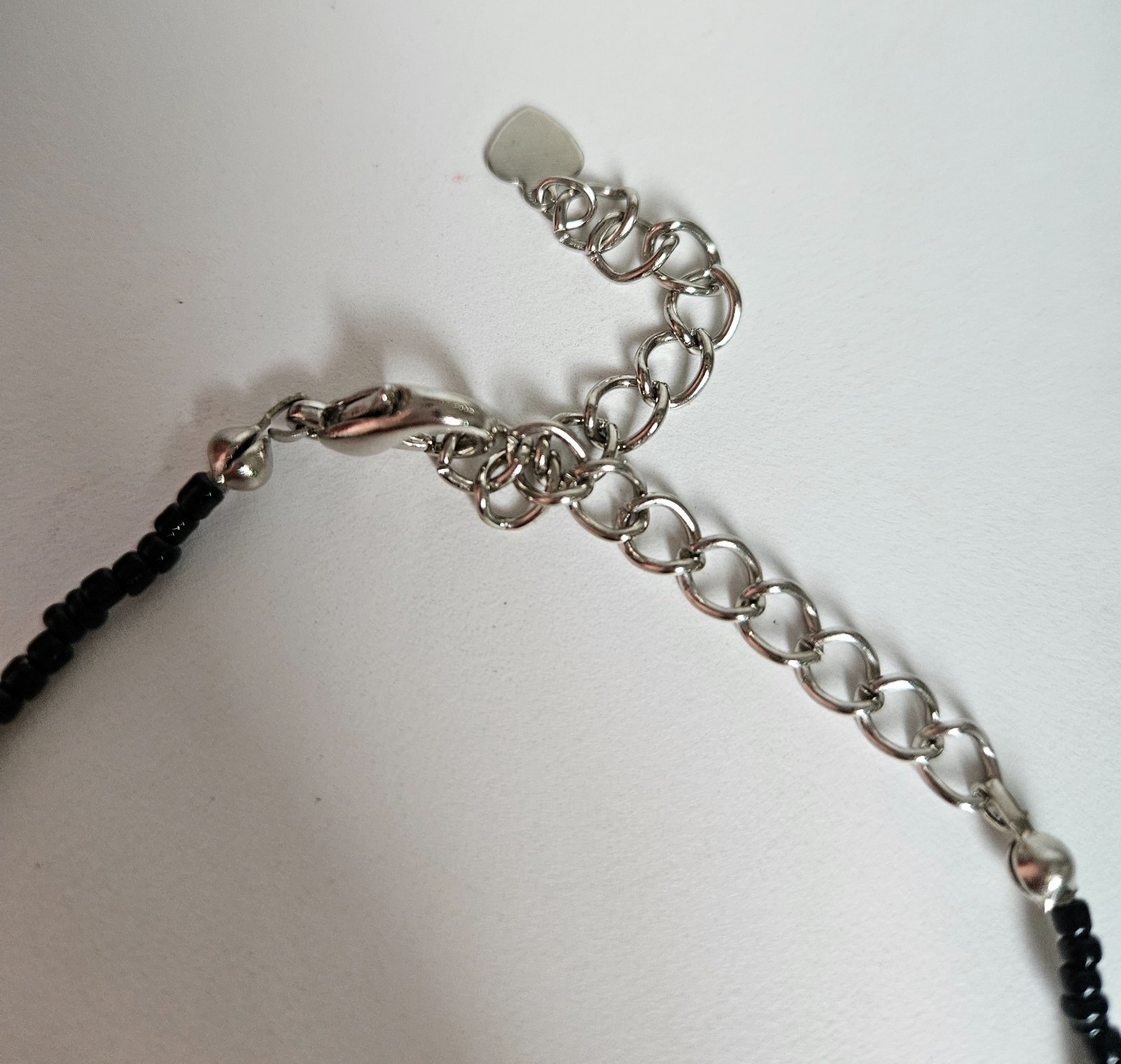 Cross pendant necklace with rhinestones on a black beaded strand