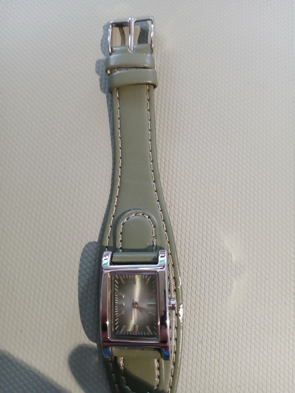 Ladies silver wathch with green face and one piece strap, new battery