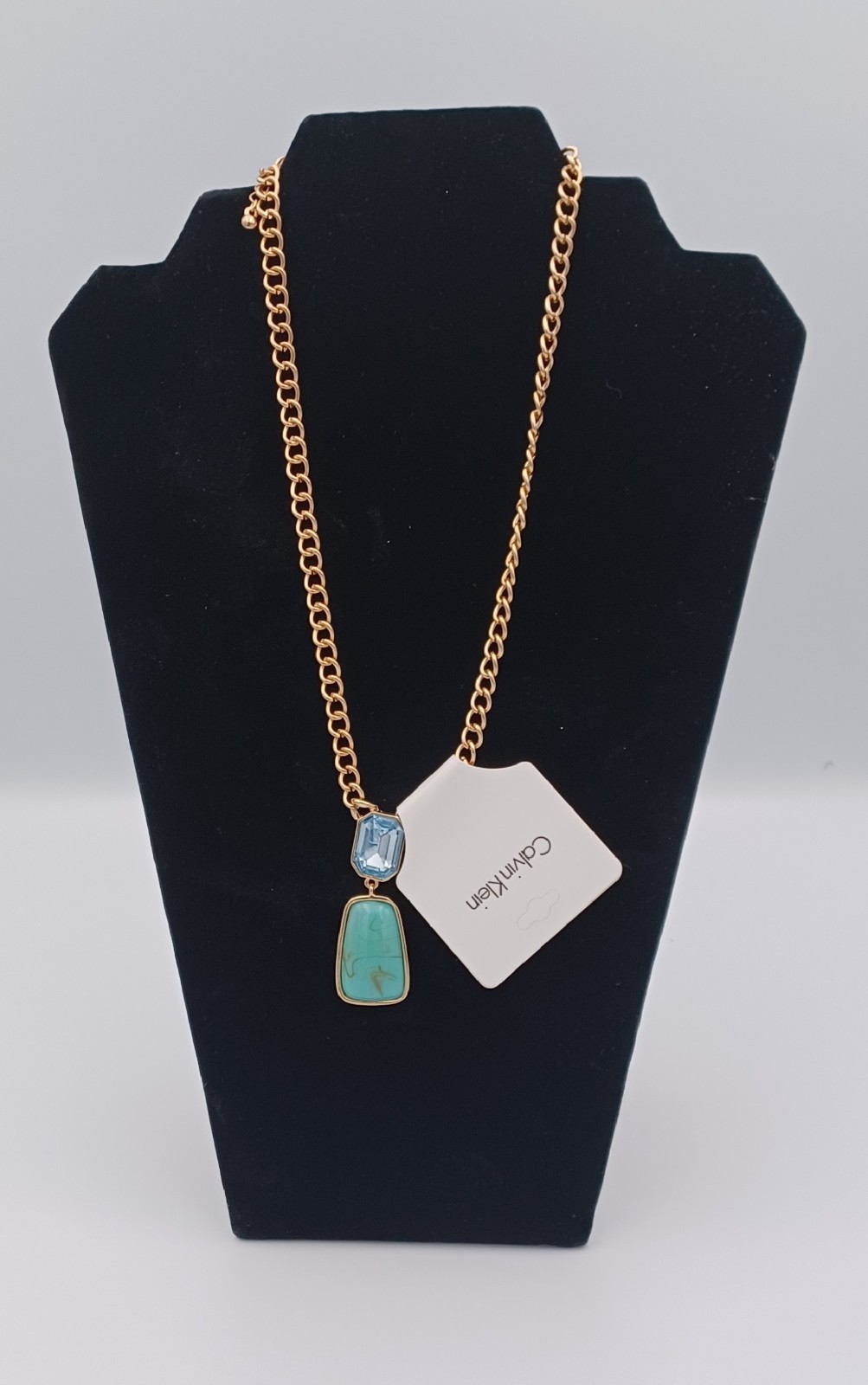 Calvin Klein gold tone necklace featuring two elegant stones in light blue and g