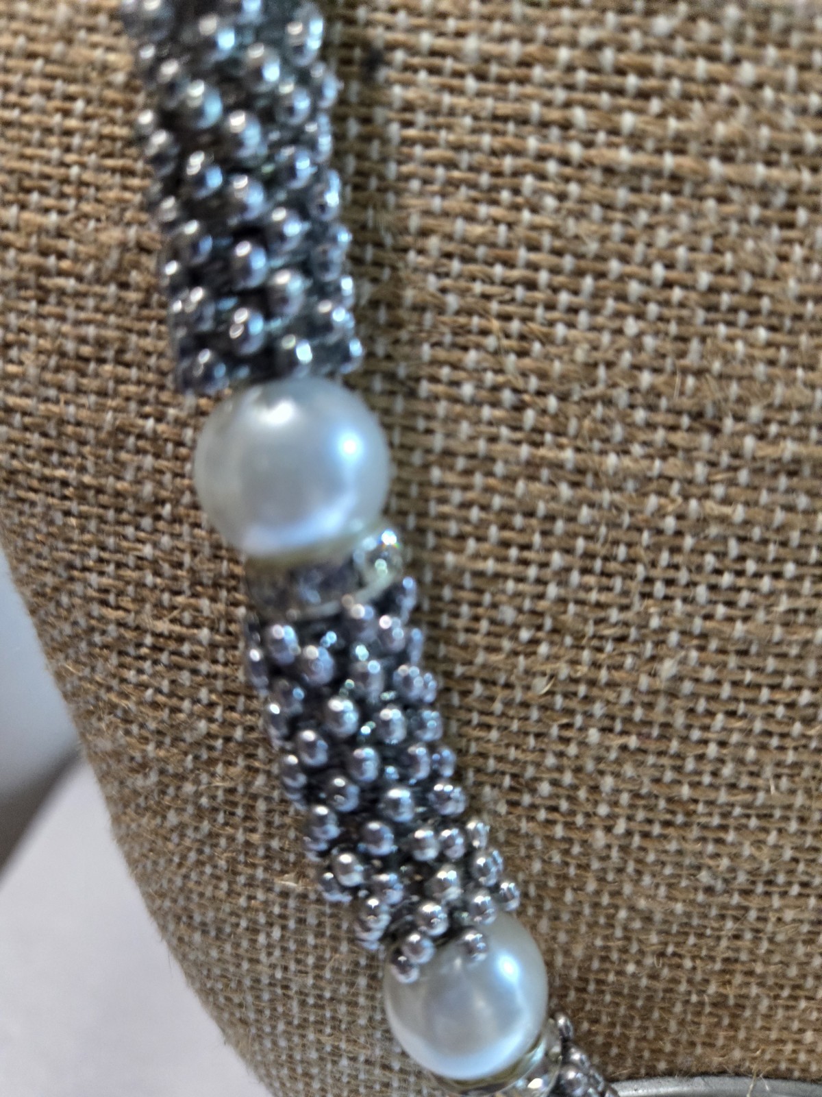 stylish silver-tone statement necklace features textured metal bead tubes…