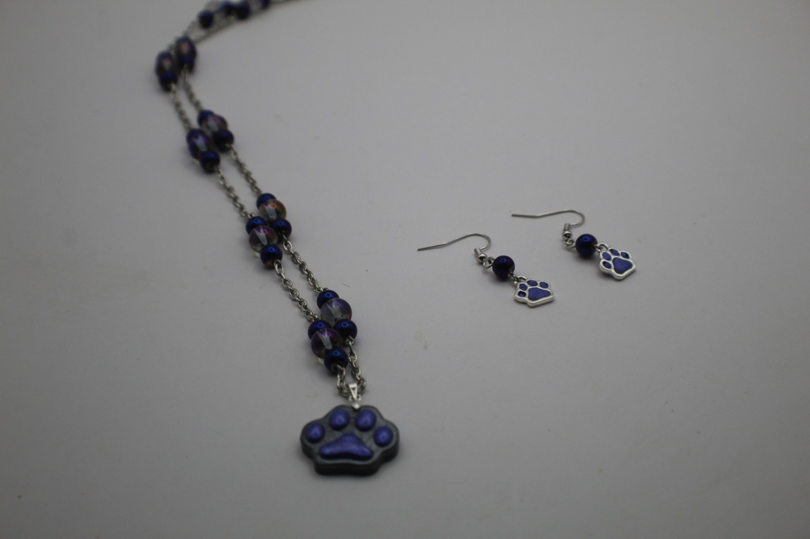 Cute Purple Paw Print Resin Pendant On A Beard Chain Necklace.