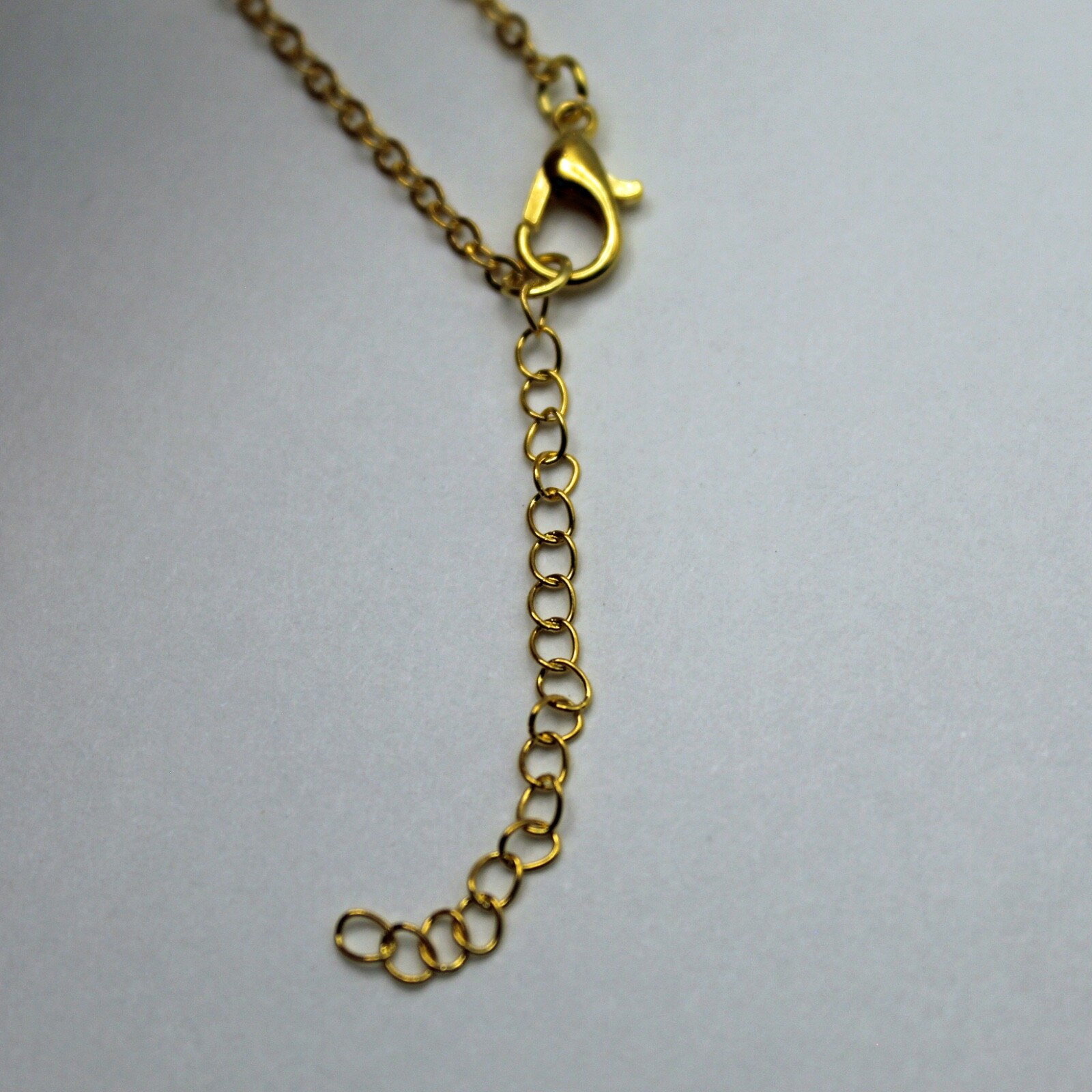 Gold Boogie Man Holding Blue Crystal Heart on 18″ Chain w/an Extension