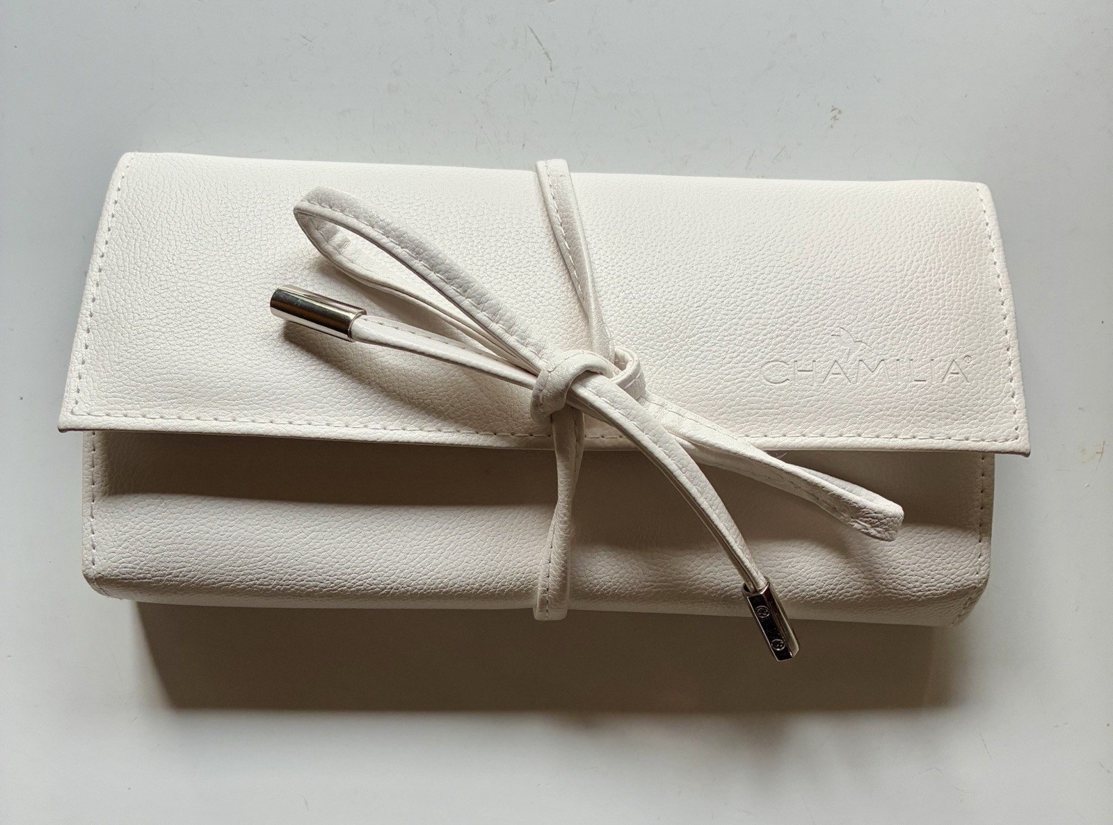 Chamilia white leatherette travel jewelry pouch with wrap-around tie closure
