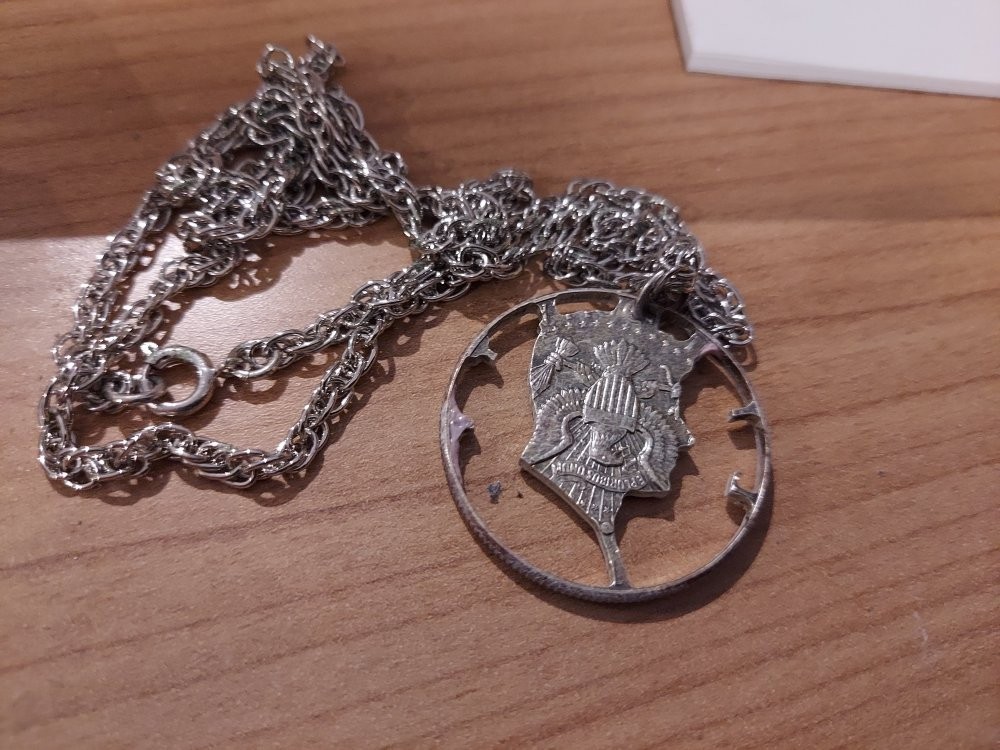 Kennedy silver half dollar cut to make a pendant on a chain