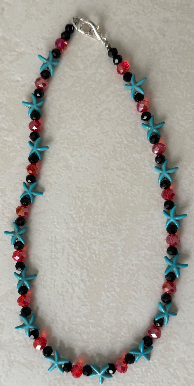 Handmade turquoise-colored starfish beads and red and black glass beads necklace