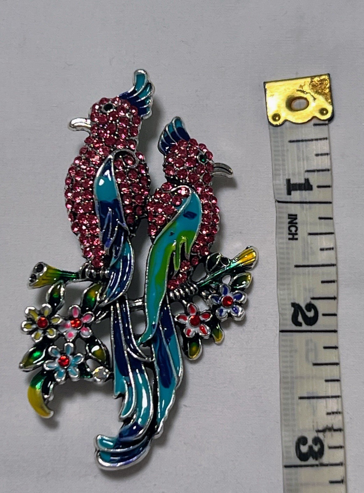 Pink rhinestone green blue enamel Birds of Paradise pin brooch sitting on flower