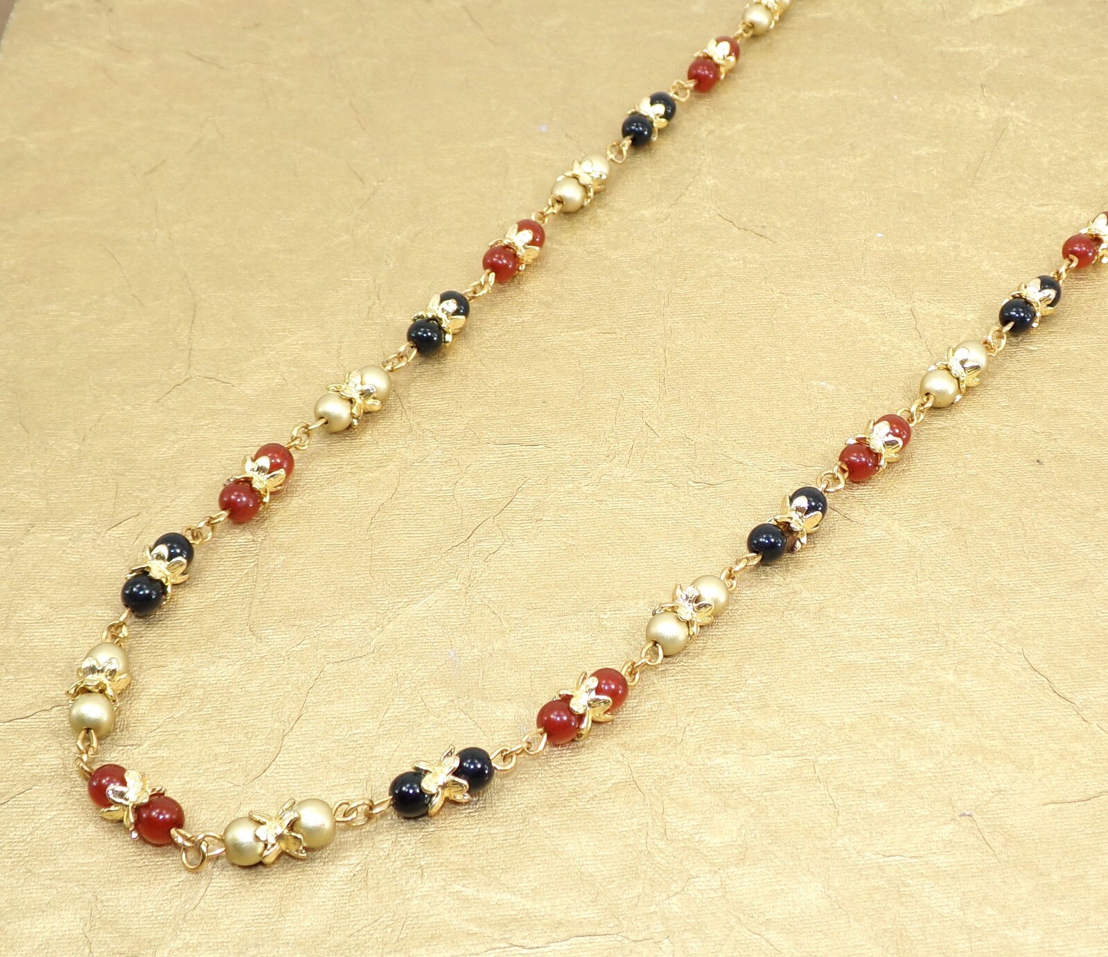 Multi color glass bead necklace with a mix of red, black, and gold colors New