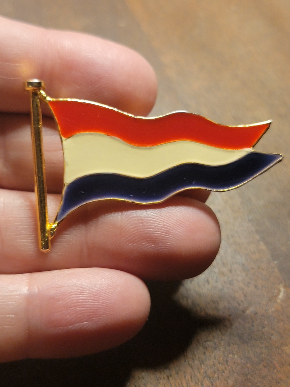 Vintage gold-toned enamel pin featuring the wavy flag of the Netherlands