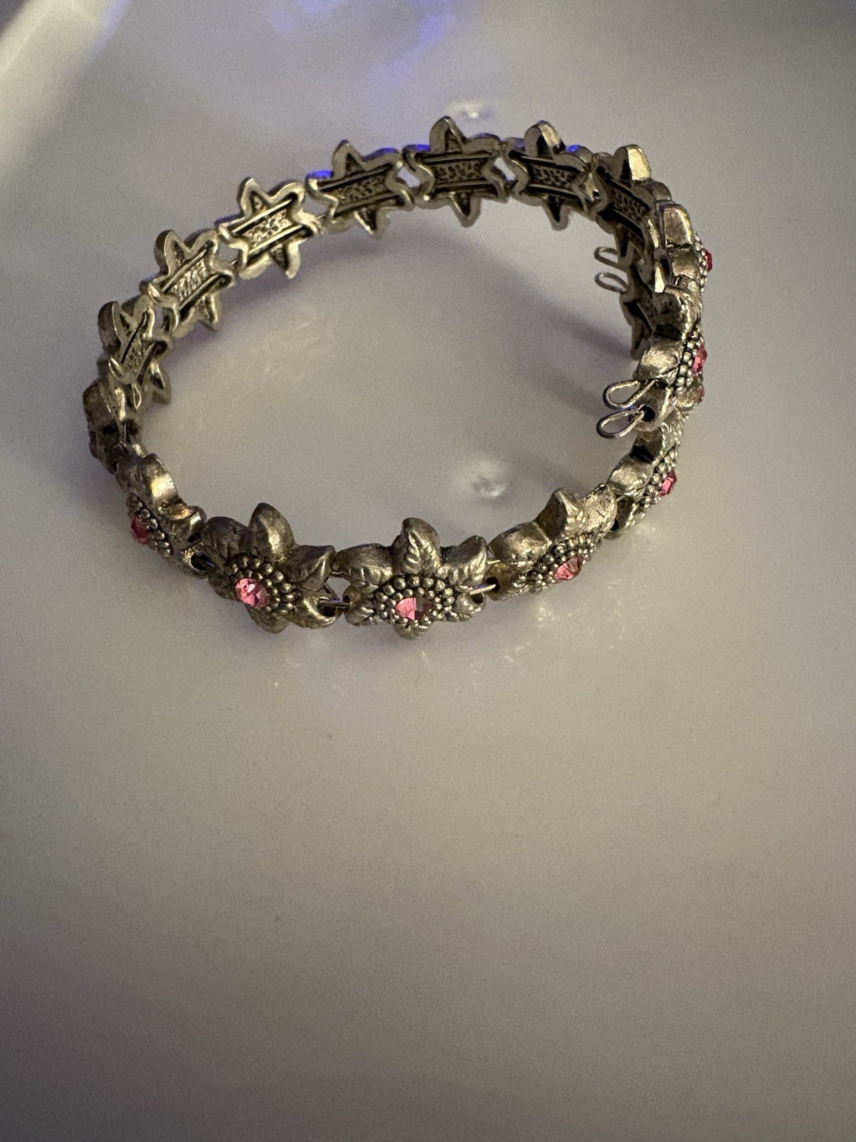 silver-toned wrap bracelet /textured metal flowers centered small pink crystals.