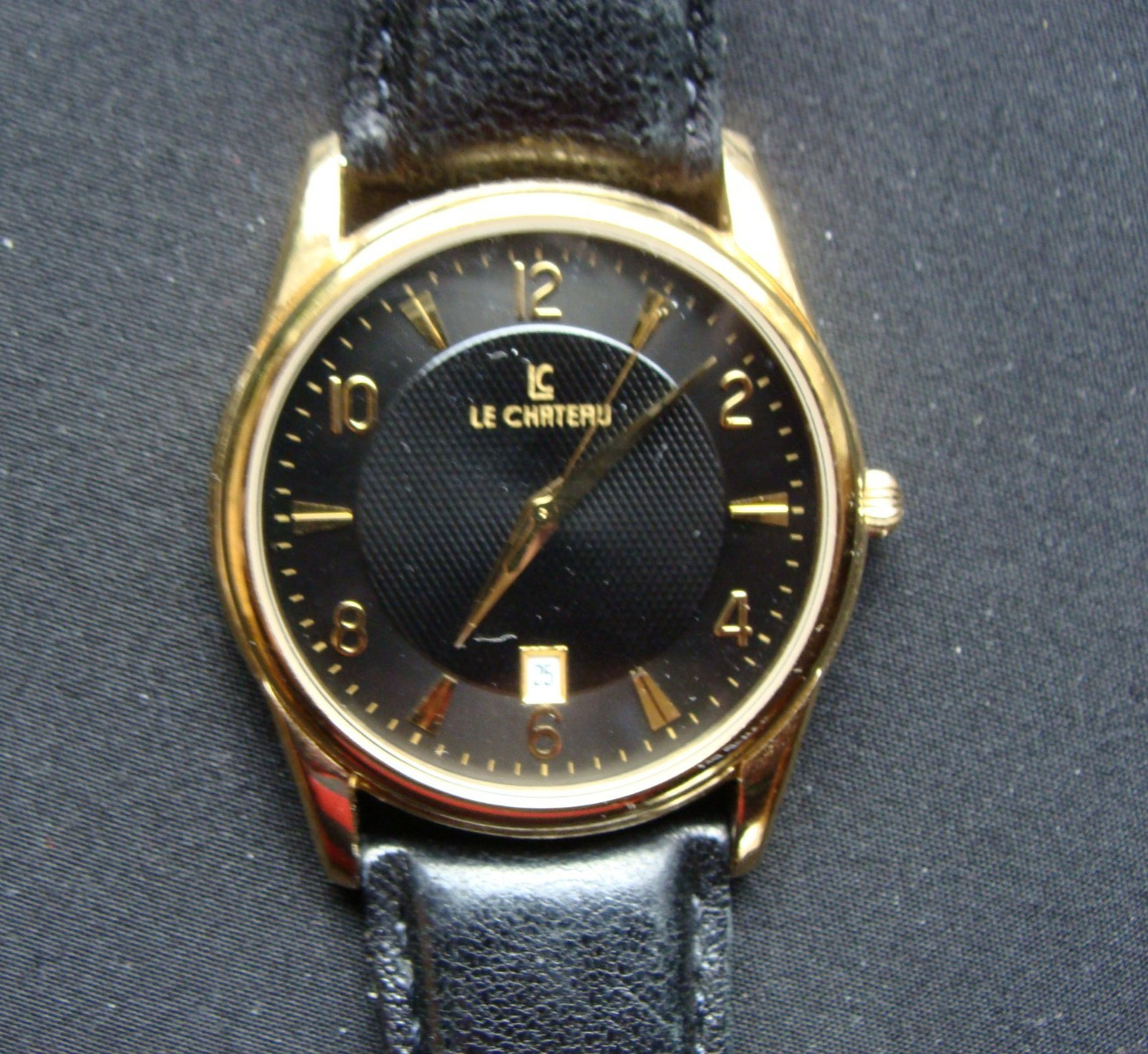 Le Chateau Men’s Black and Gold Watch. Very good condition. Keeps great time!