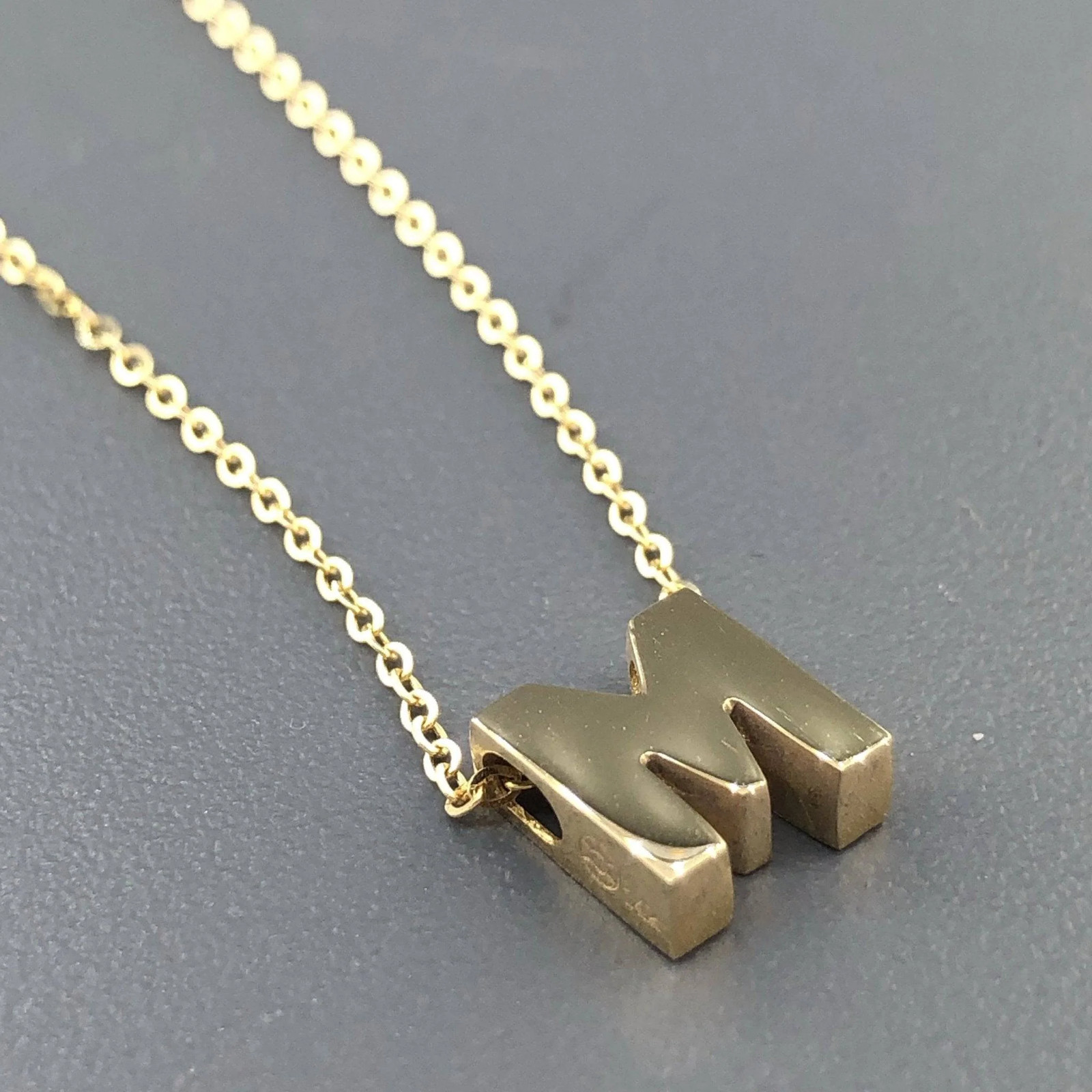 14K Yellow Gold initial ‘M’ pendant on a 16″ chain with a 2″ extender.