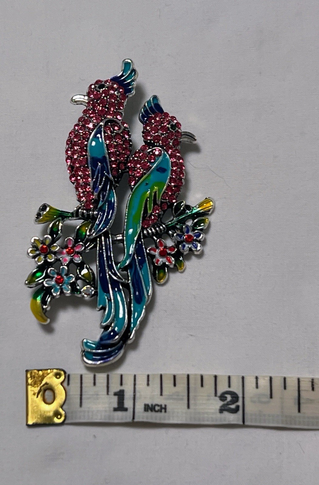 Pink rhinestone green blue enamel Birds of Paradise pin brooch sitting on flower