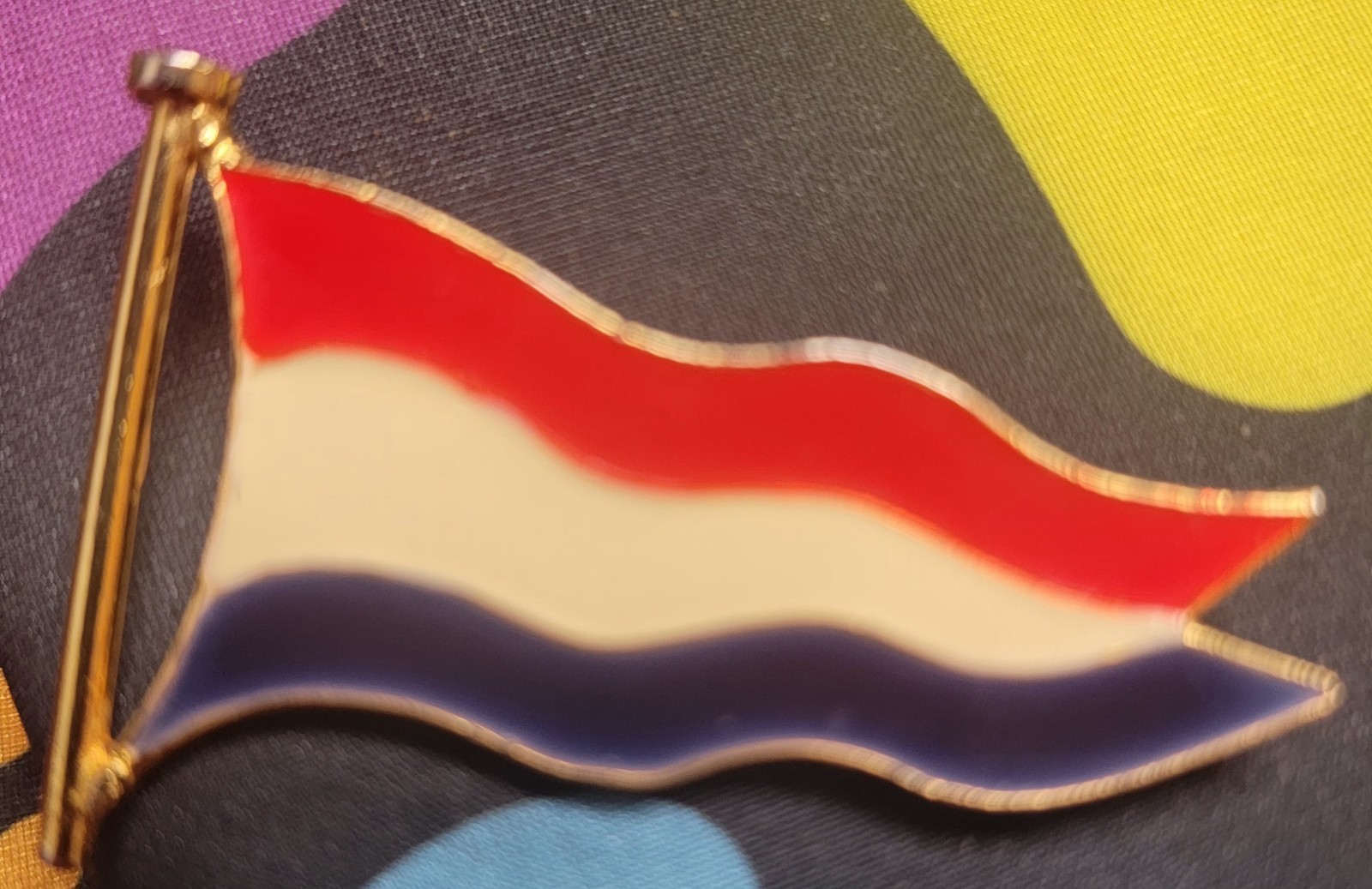 Vintage gold-toned enamel pin featuring the wavy flag of the Netherlands