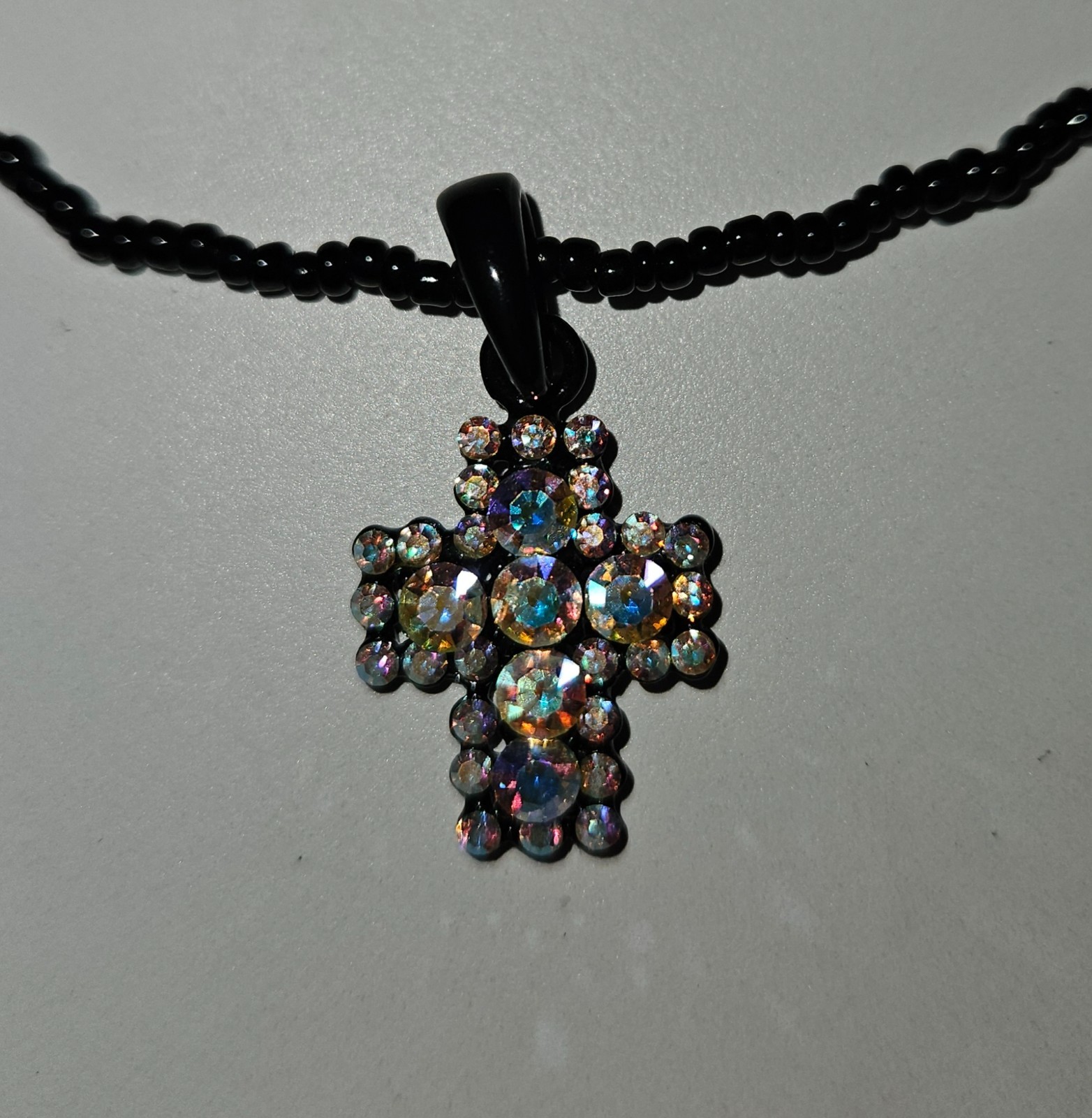 Cross pendant necklace with rhinestones on a black beaded strand