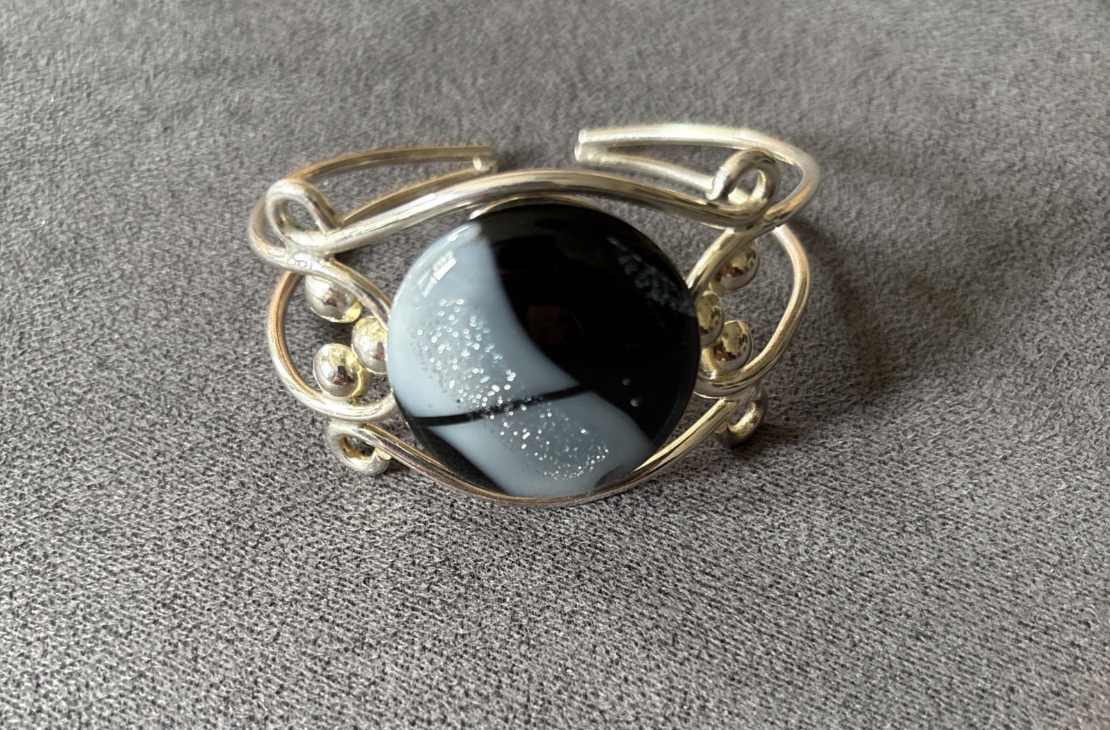 Silver wire cuff bracelet with circular dichroic glass black/gray cabochon
