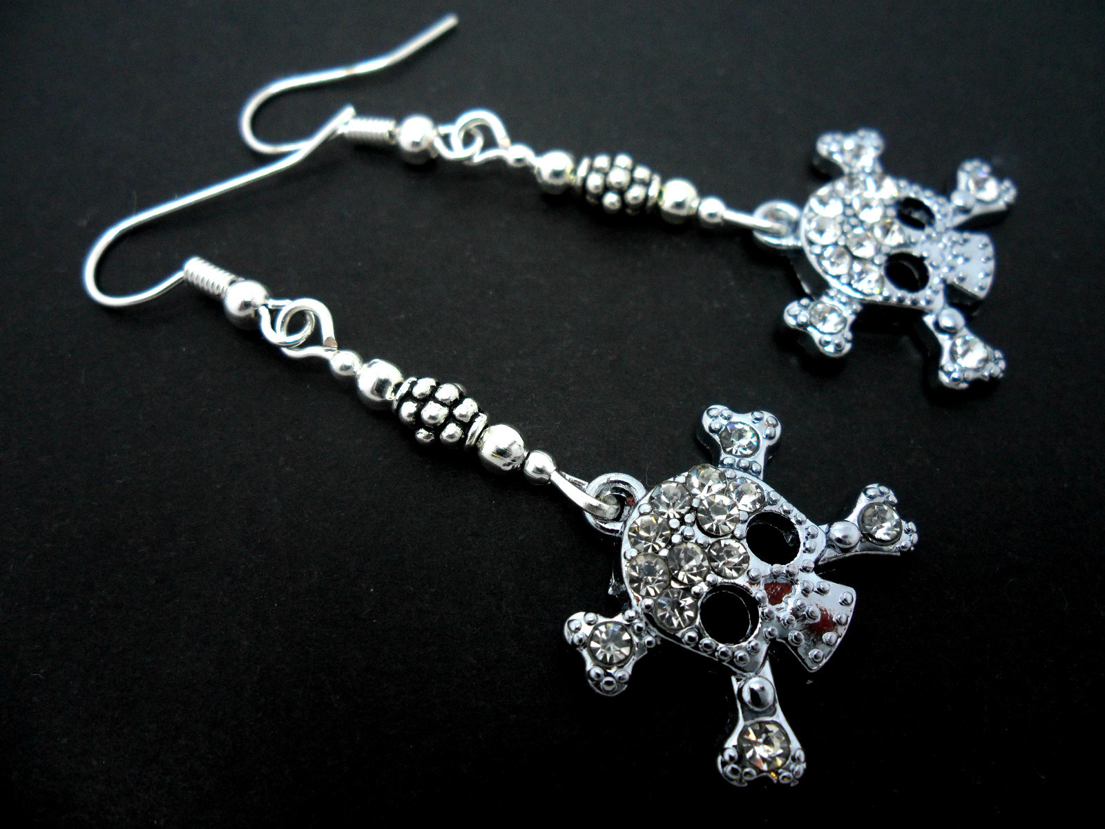 A PAIR OF DIAMANTE/RHINESTONE SKULL THEMED DANGLY EARRINGS.