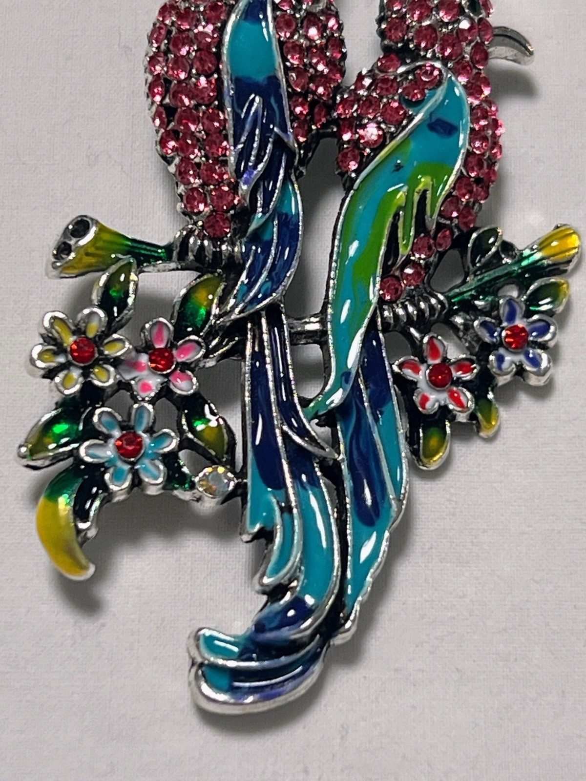 Pink rhinestone green blue enamel Birds of Paradise pin brooch sitting on flower