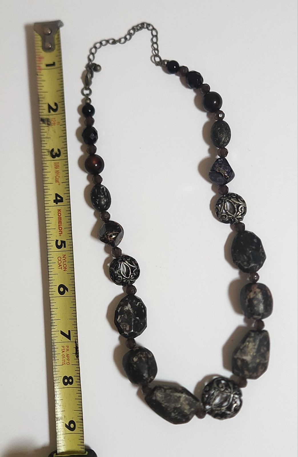 Handmade artisan necklace features chunky, speckled black beads and ornate.