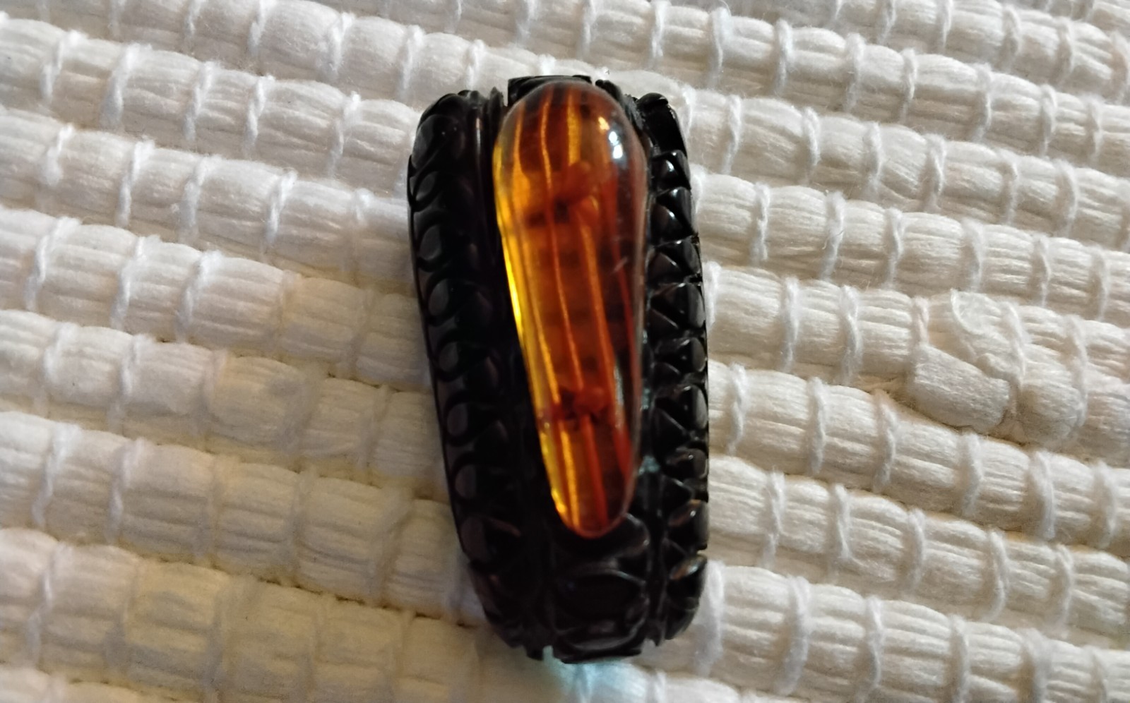 Beautiful Applejuice and black Bakelite carved dress clip
