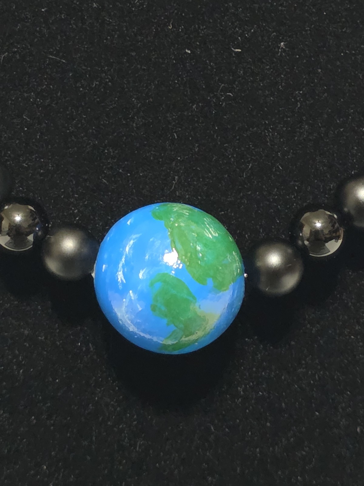18.5in planet Earth hand painted with matte black and gloss black gemstones…
