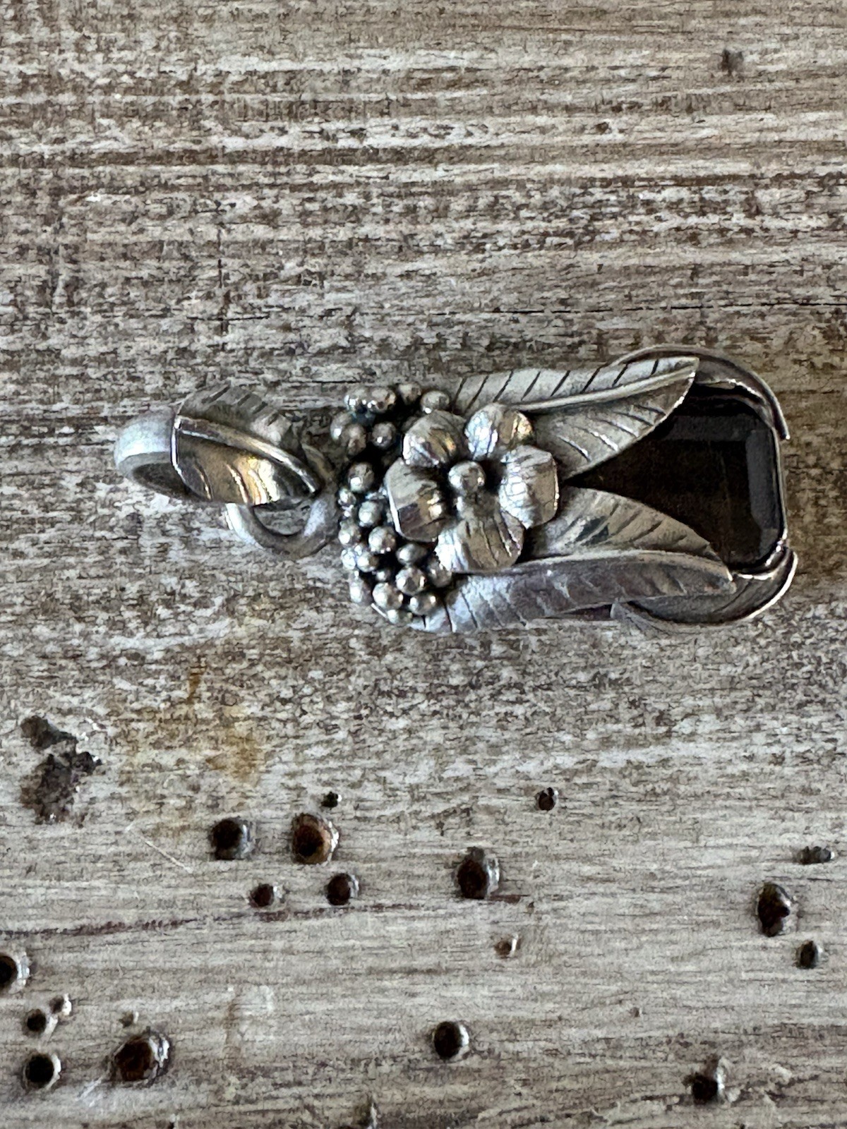 Marked 925 , stone surrounded with silver flower,leaves and berries