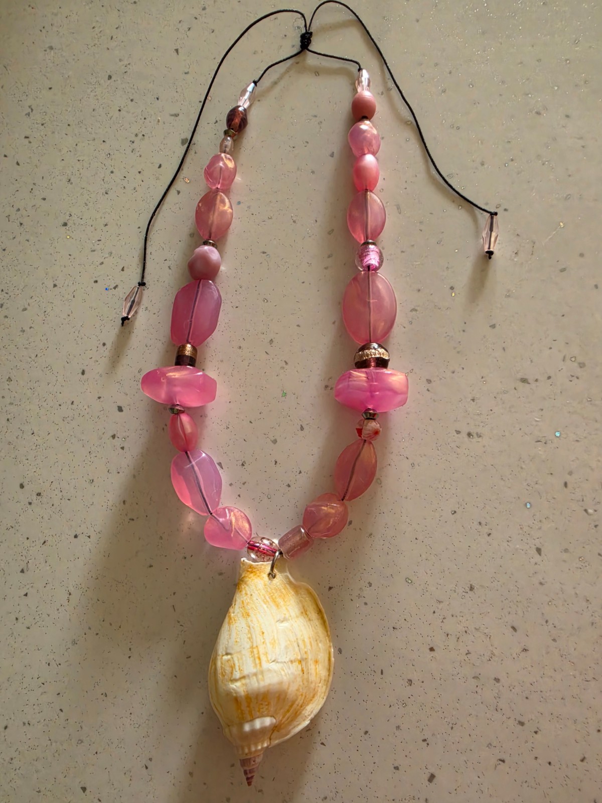 Collar veraniego confeccionado en hilo chino con largo ajustable en tonos rosa