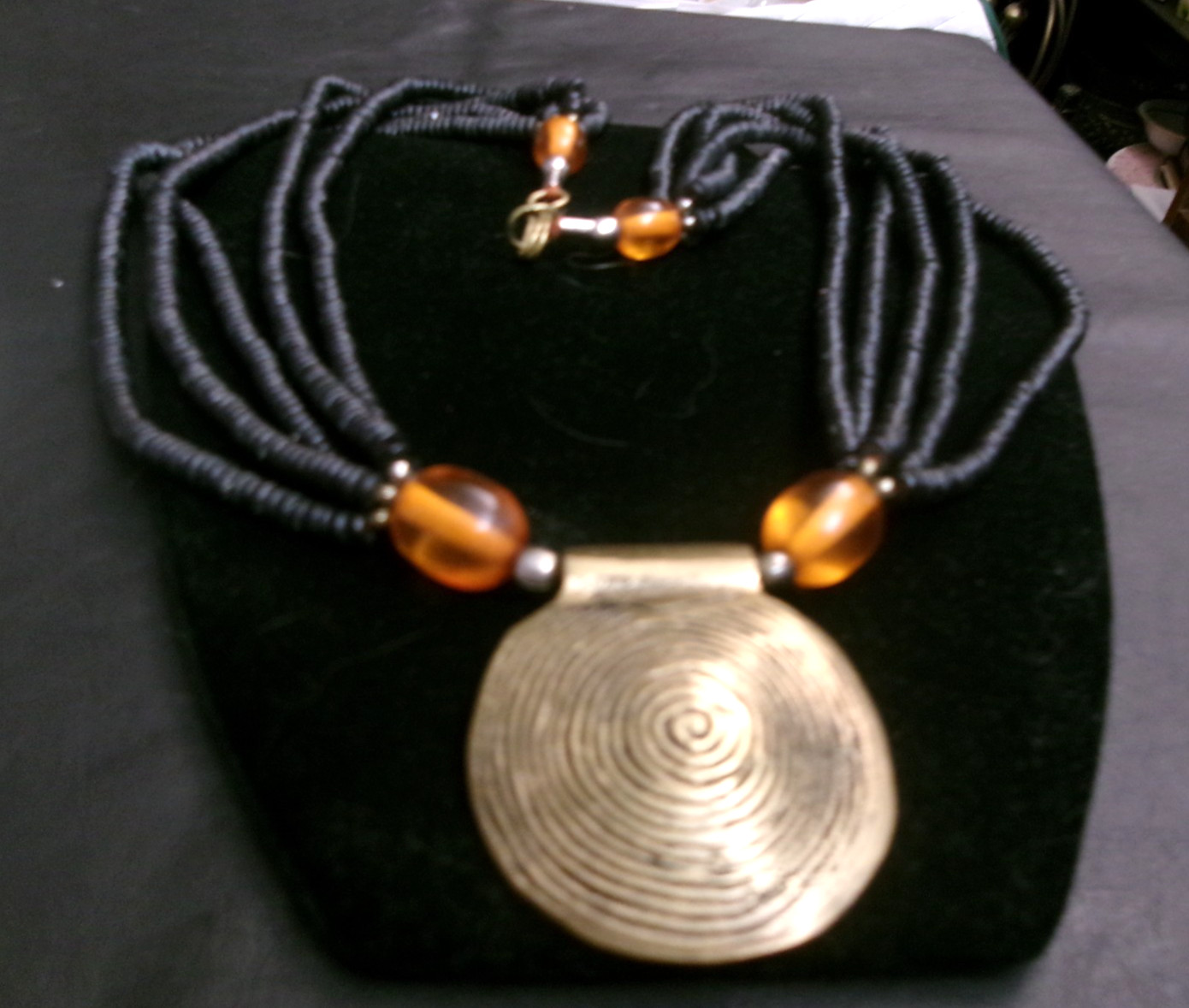 African ethnic tribal necklace features a round pendant brass