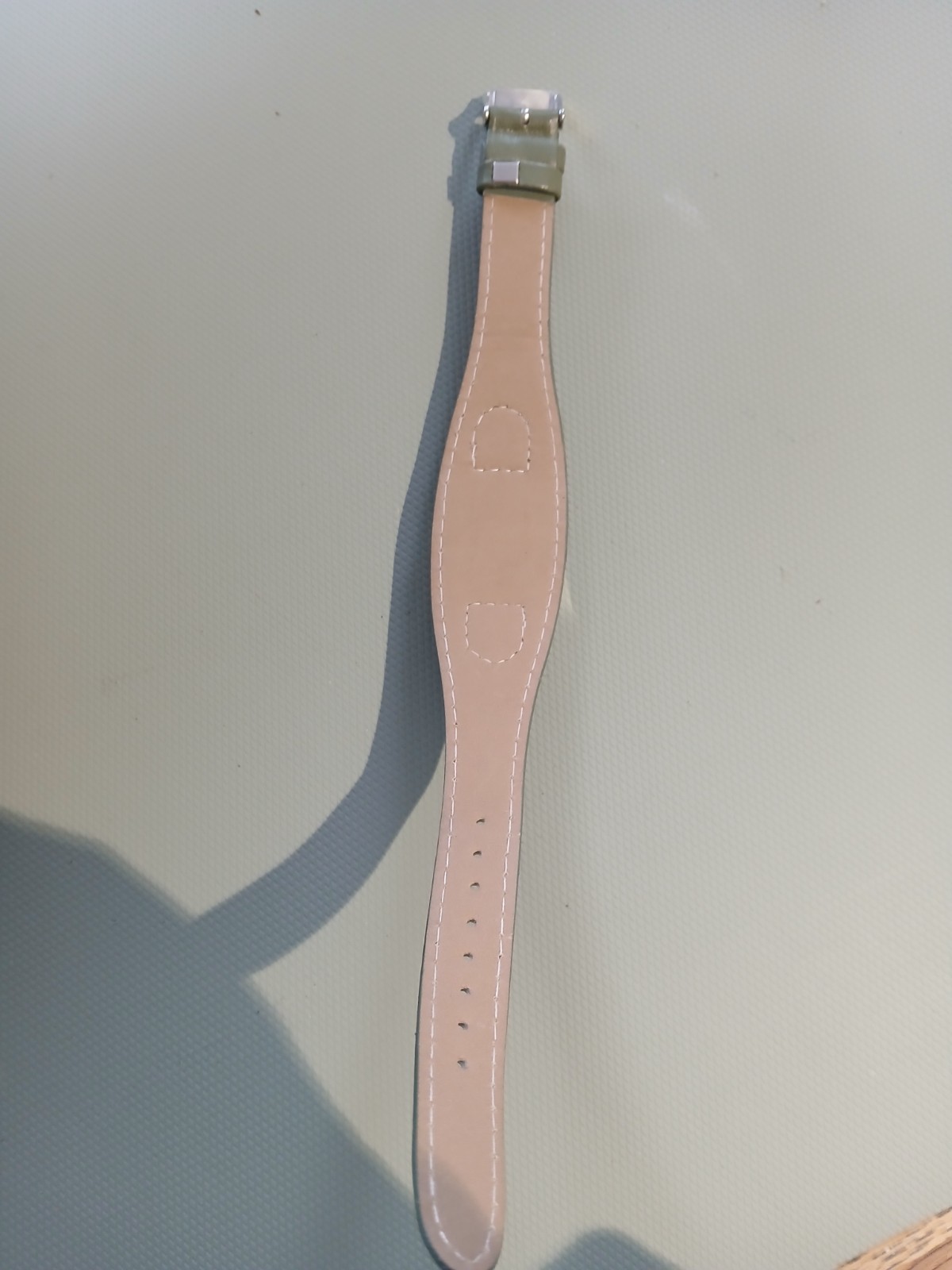 Ladies silver wathch with green face and one piece strap, new battery