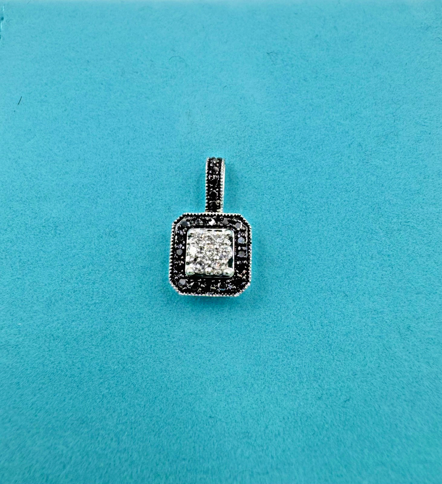 1.1 gram 14k White gold pendant feat. black and white diamonds