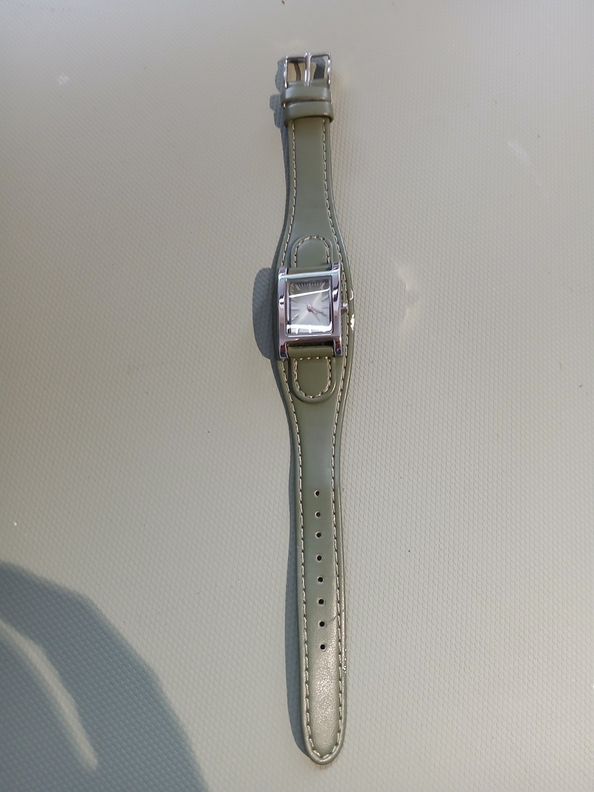 Ladies silver wathch with green face and one piece strap, new battery