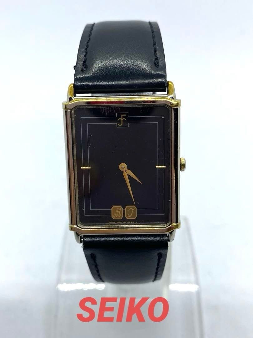 SEIKO rectangular quartz watch with black leather strap.