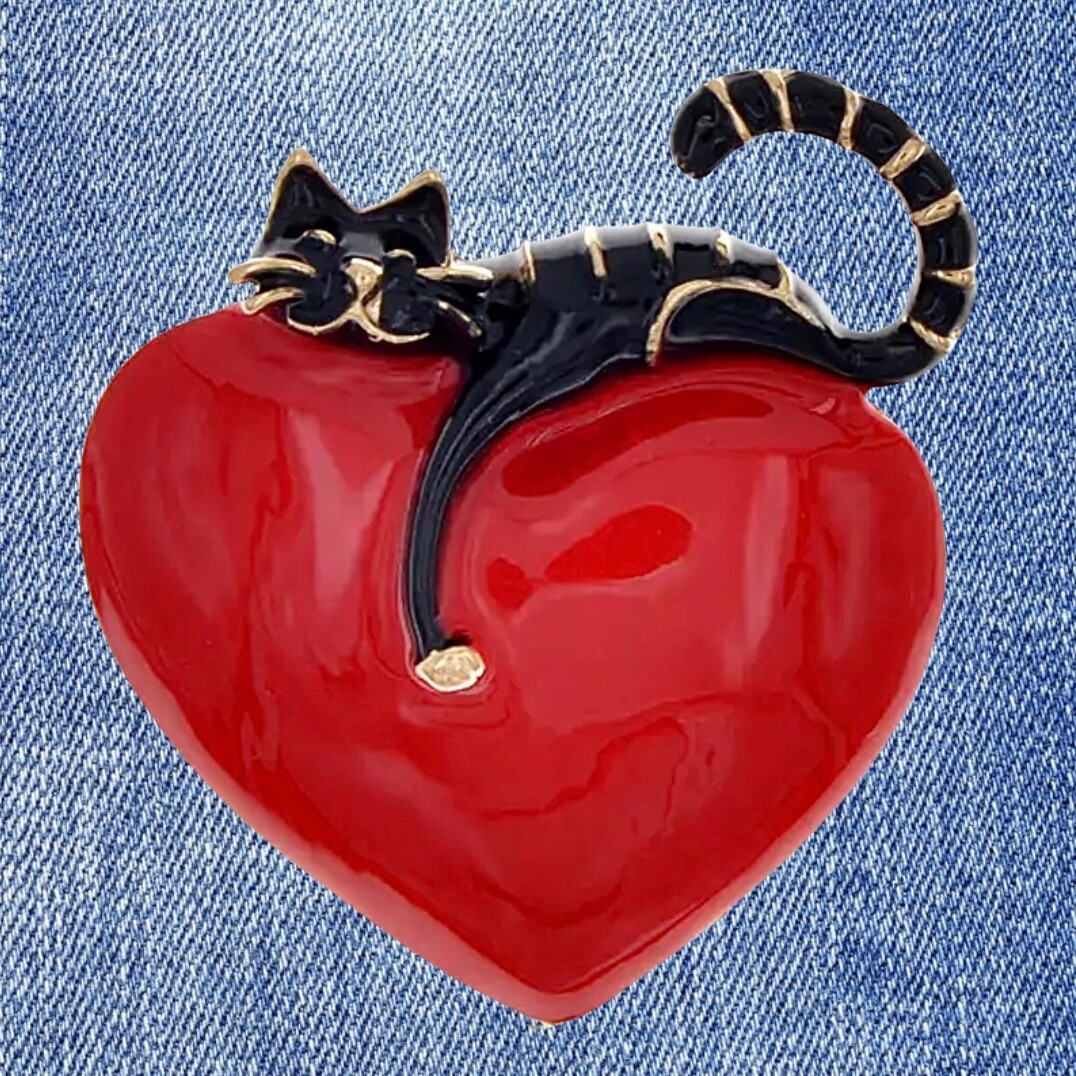 Rich red, shiny heart with comfy cat resting on top. Puffed up. Pin, brooch.