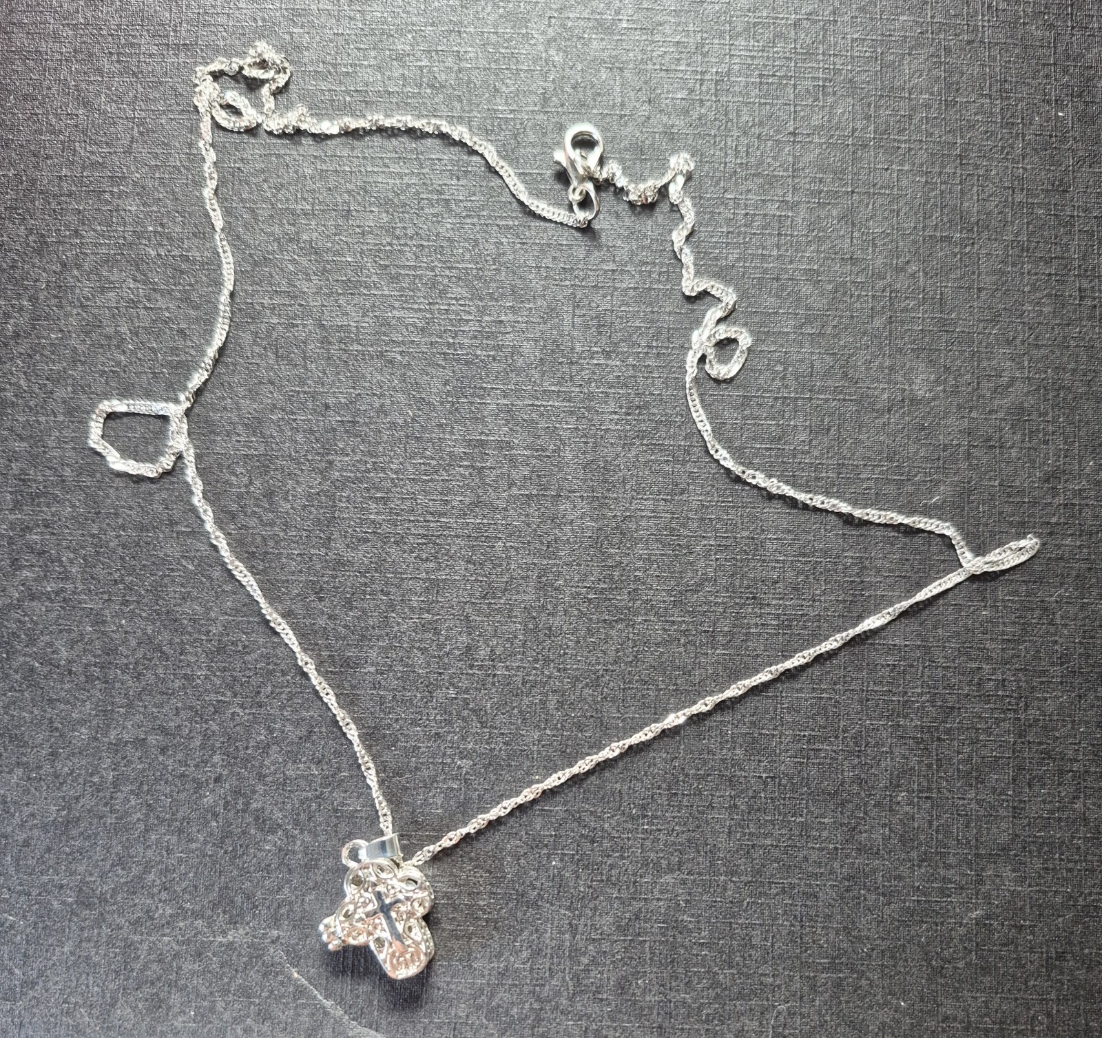 textured silver-tone chain and a cross pendant adorned with sparkling crystals