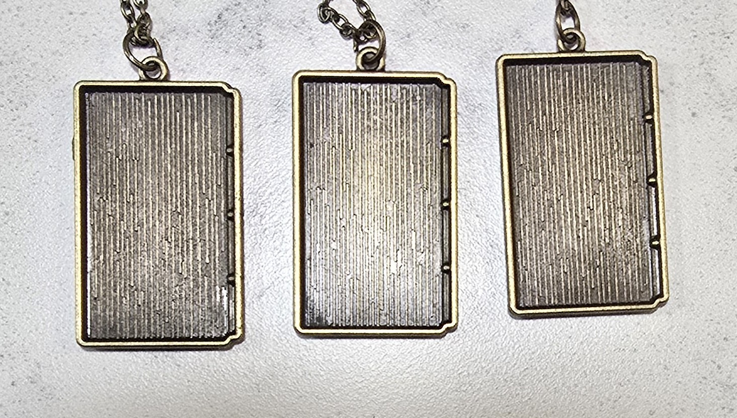 Three George R.R. Martin Book Cover Pendants With Chains – About 1 Inch Each