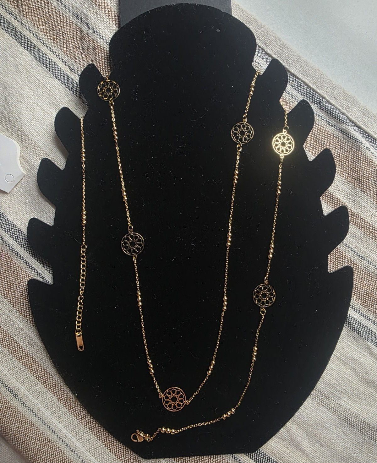 long gold-colored necklace featuring varied patterns and a rust-resistant finish