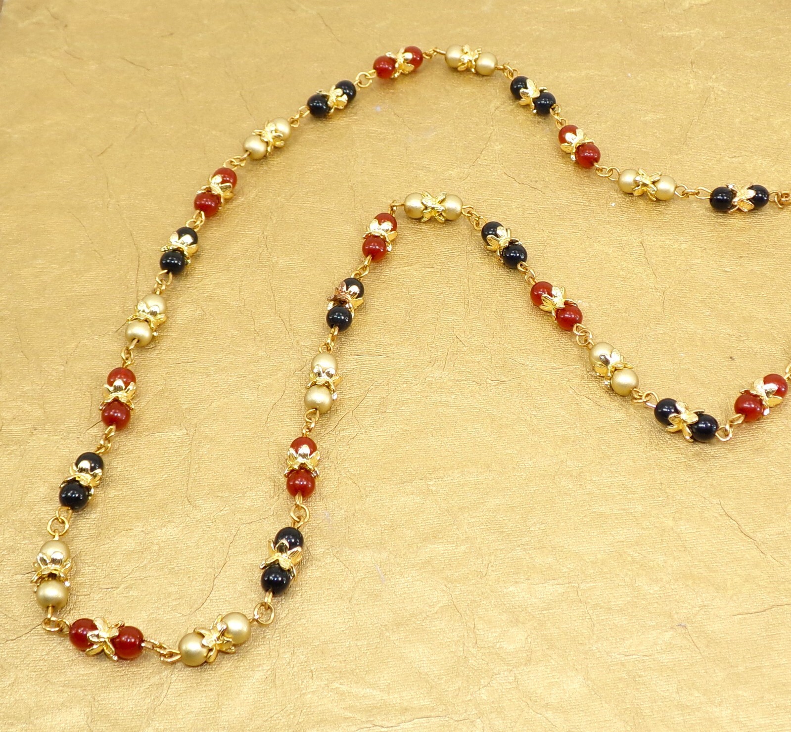 Multi color glass bead necklace with a mix of red, black, and gold colors New