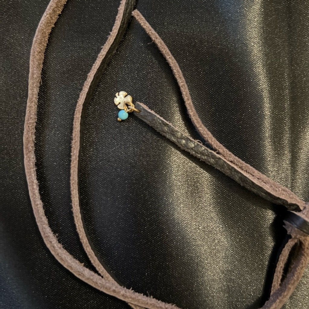 GUC- Lucky Brand brass like feather pendant on leather rope.