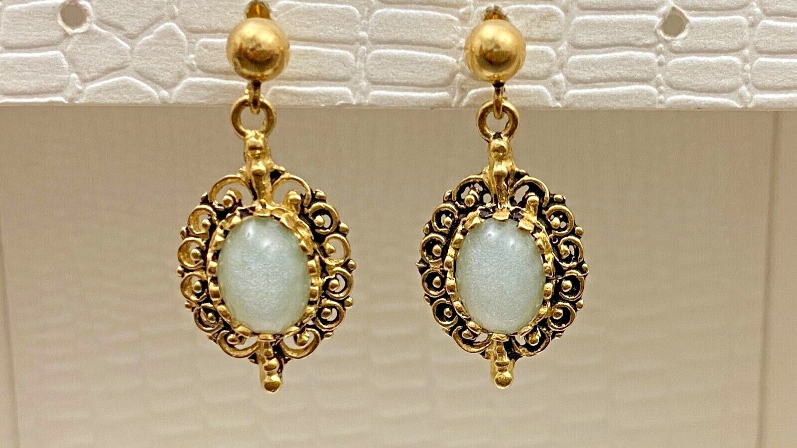 14k Yellow Gold Drop Style Earrings set with an Oval Opal Green/Blue flashes.