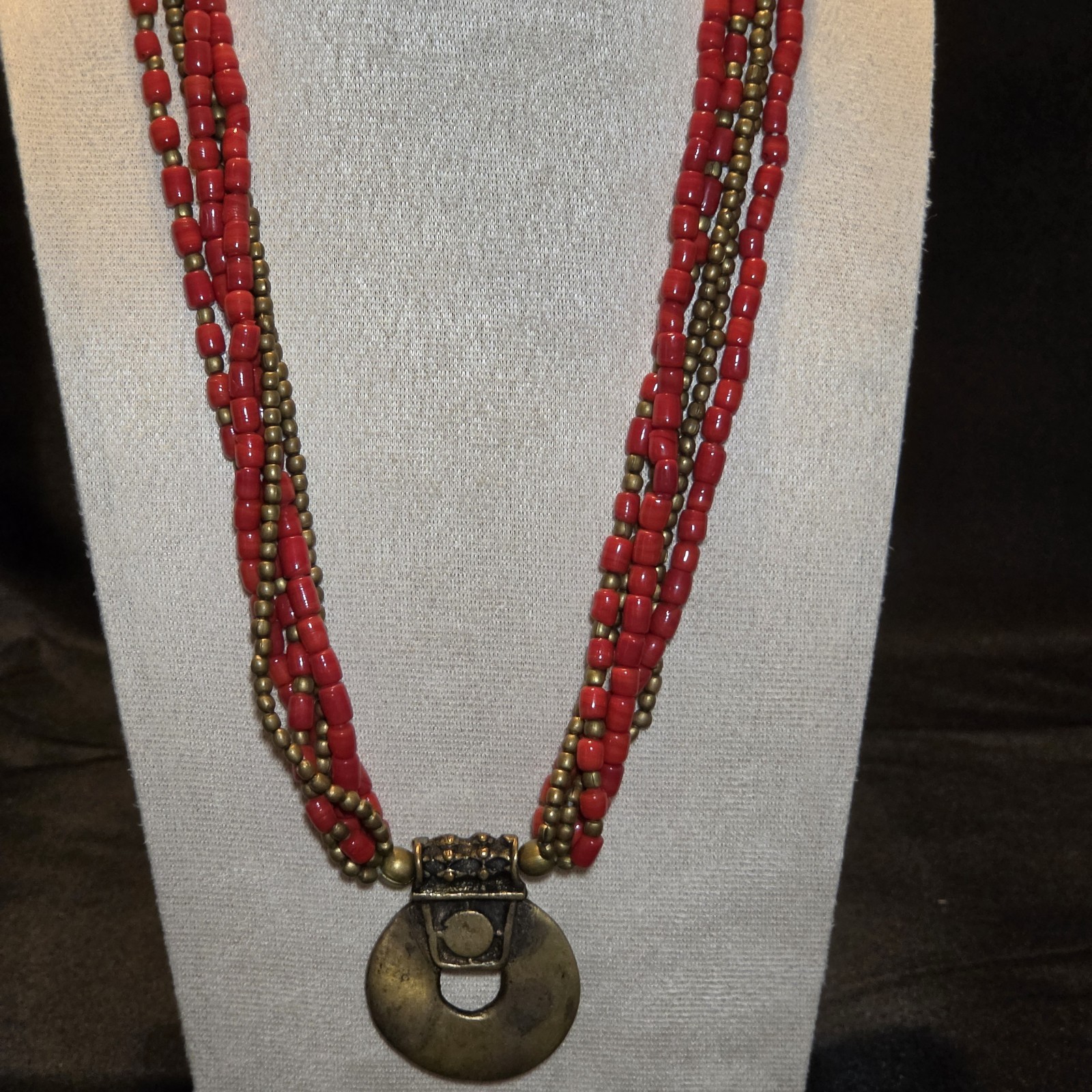 Red Beaded Multi-strand Necklace With Antique Brass Pendant.