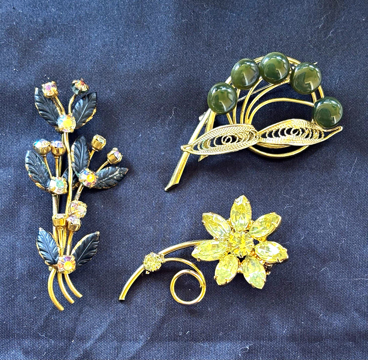 Lot of 3 gold tone floral brooches one signed