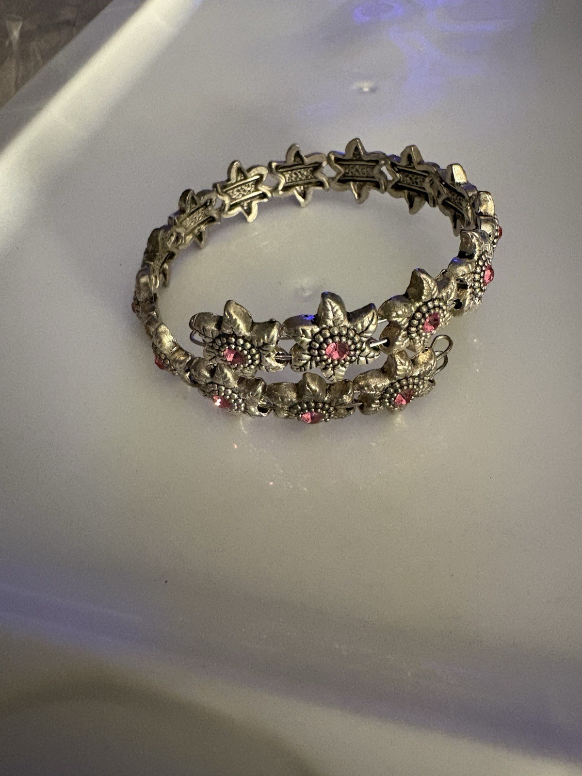 silver-toned wrap bracelet /textured metal flowers centered small pink crystals.