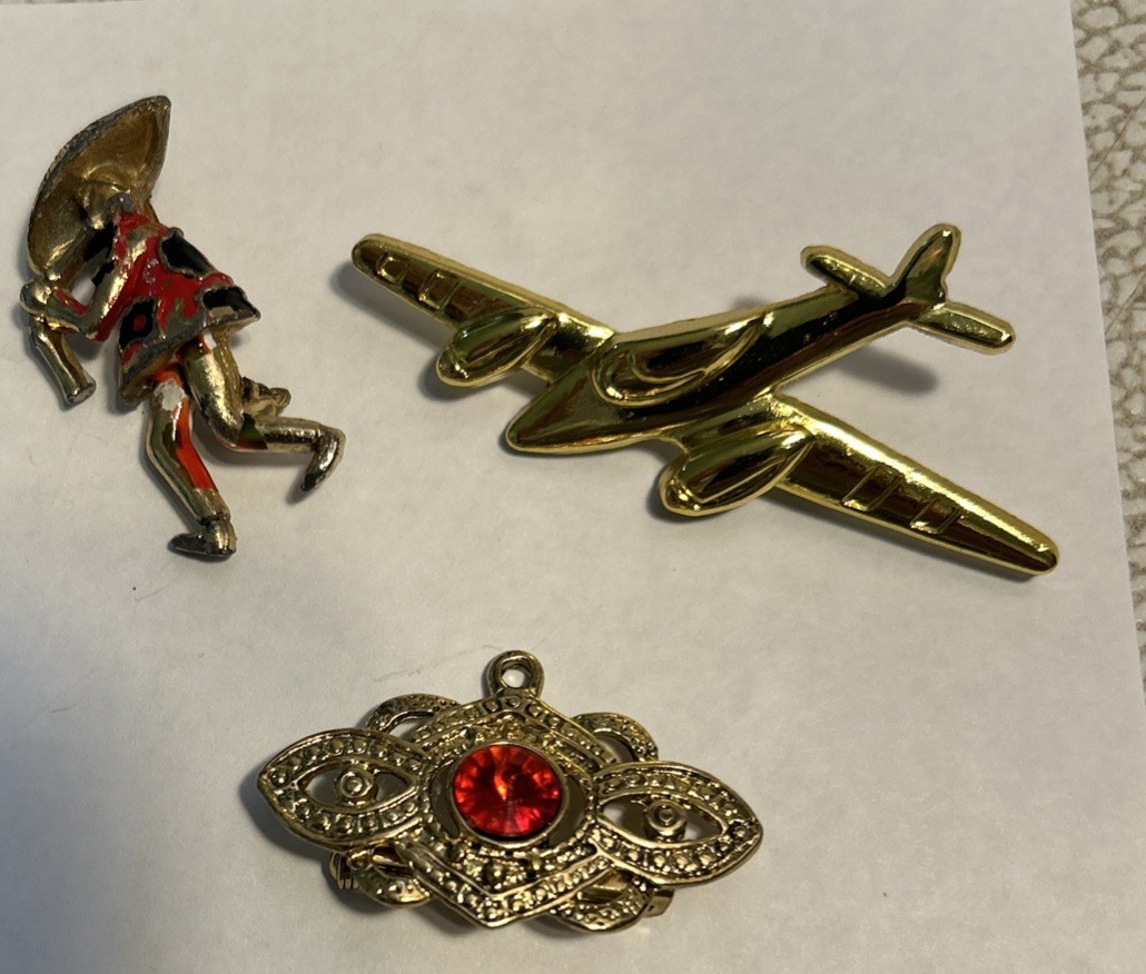 Lot Of 3 Jewelry Pieces Depicting A Rural Farmer, A Floret, Messerschmit plane