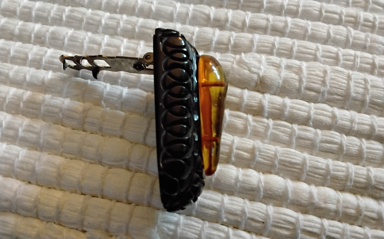Beautiful Applejuice and black Bakelite carved dress clip
