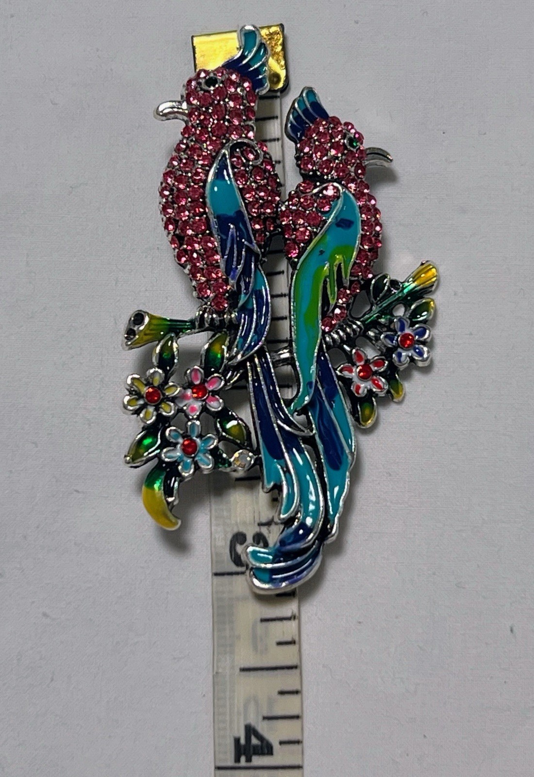 Pink rhinestone green blue enamel Birds of Paradise pin brooch sitting on flower