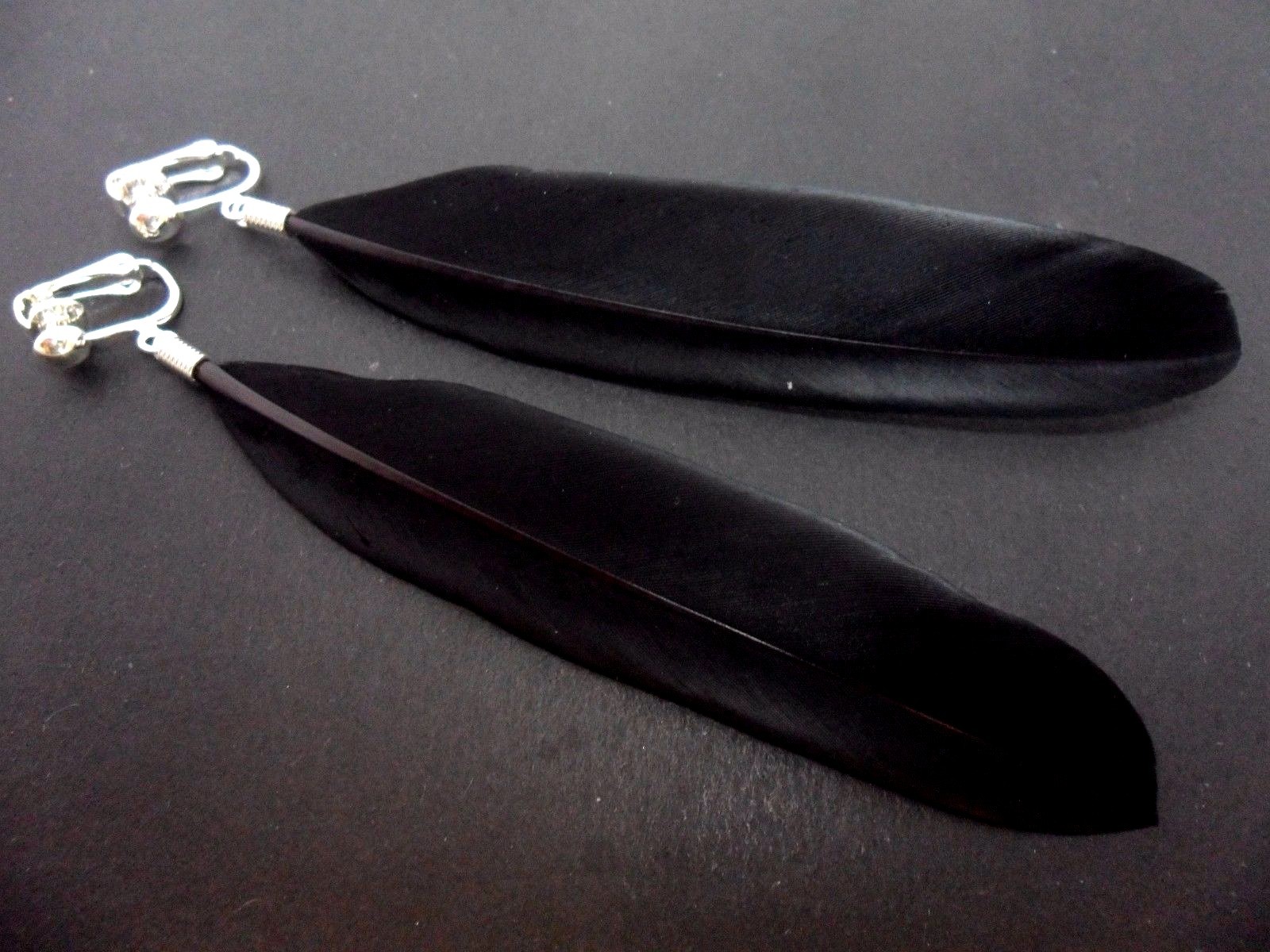 A PAIR OF LONG BLACK FEATHER DANGLY CLIP ON EARRINGS.