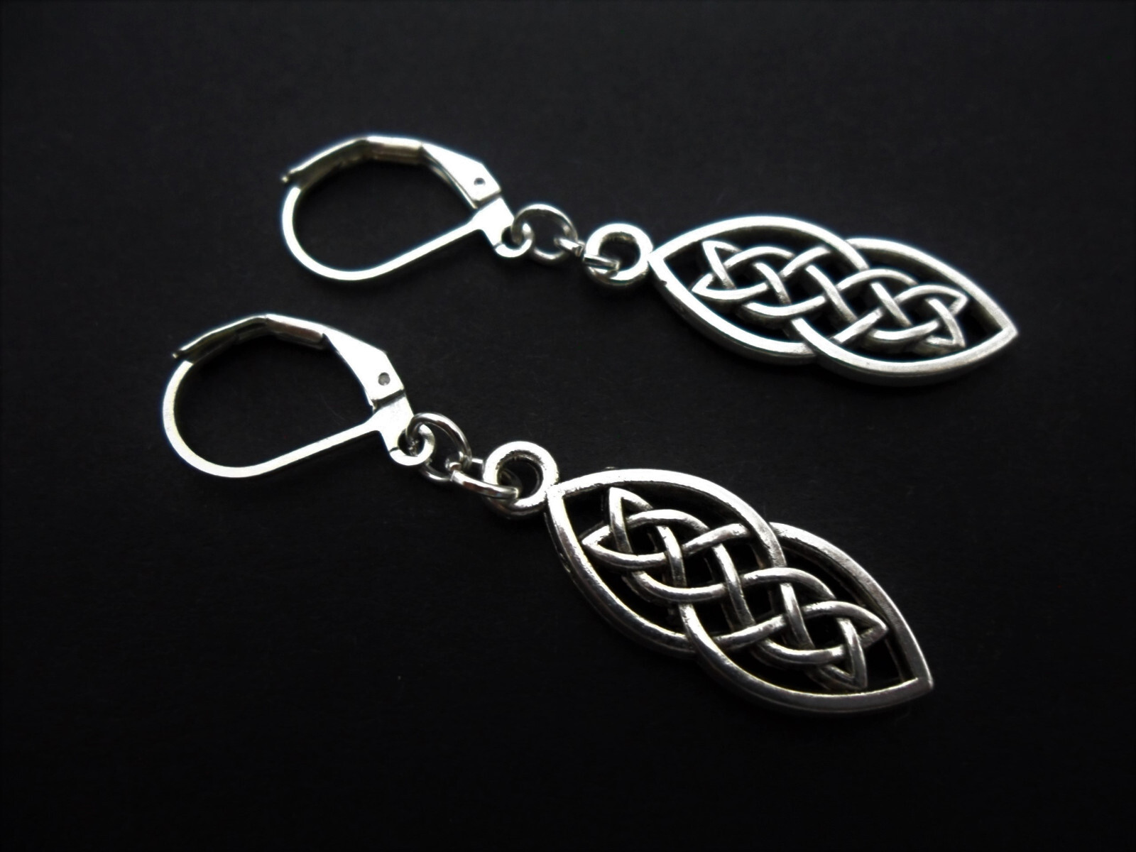 A PAIR OF TIBETAN SILVER CELTIC KNOT THEMED DANGLY LEVERBACK HOOK EARRINGS.