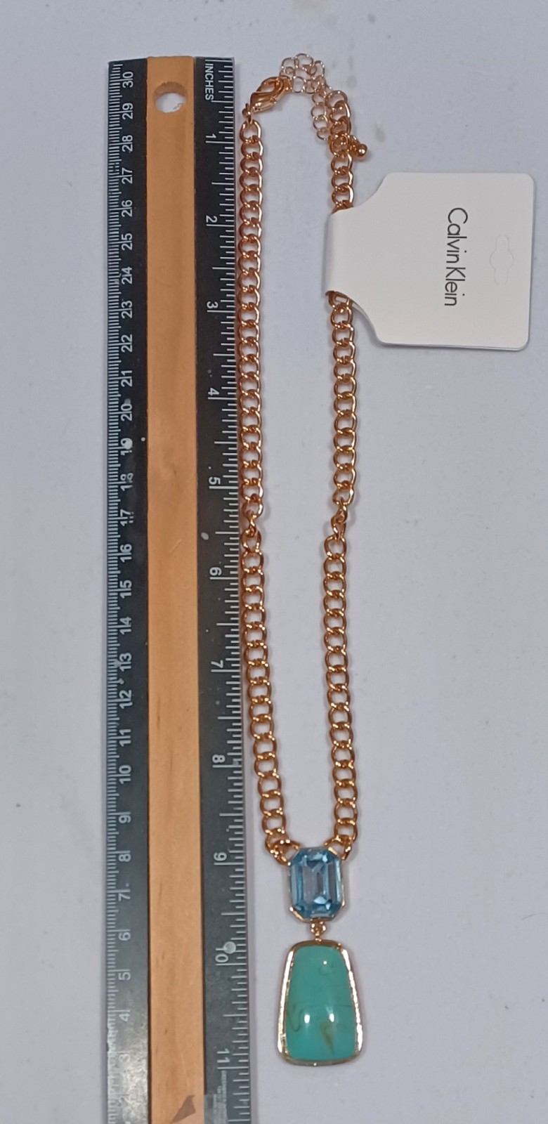 Calvin Klein gold tone necklace featuring two elegant stones in light blue and g