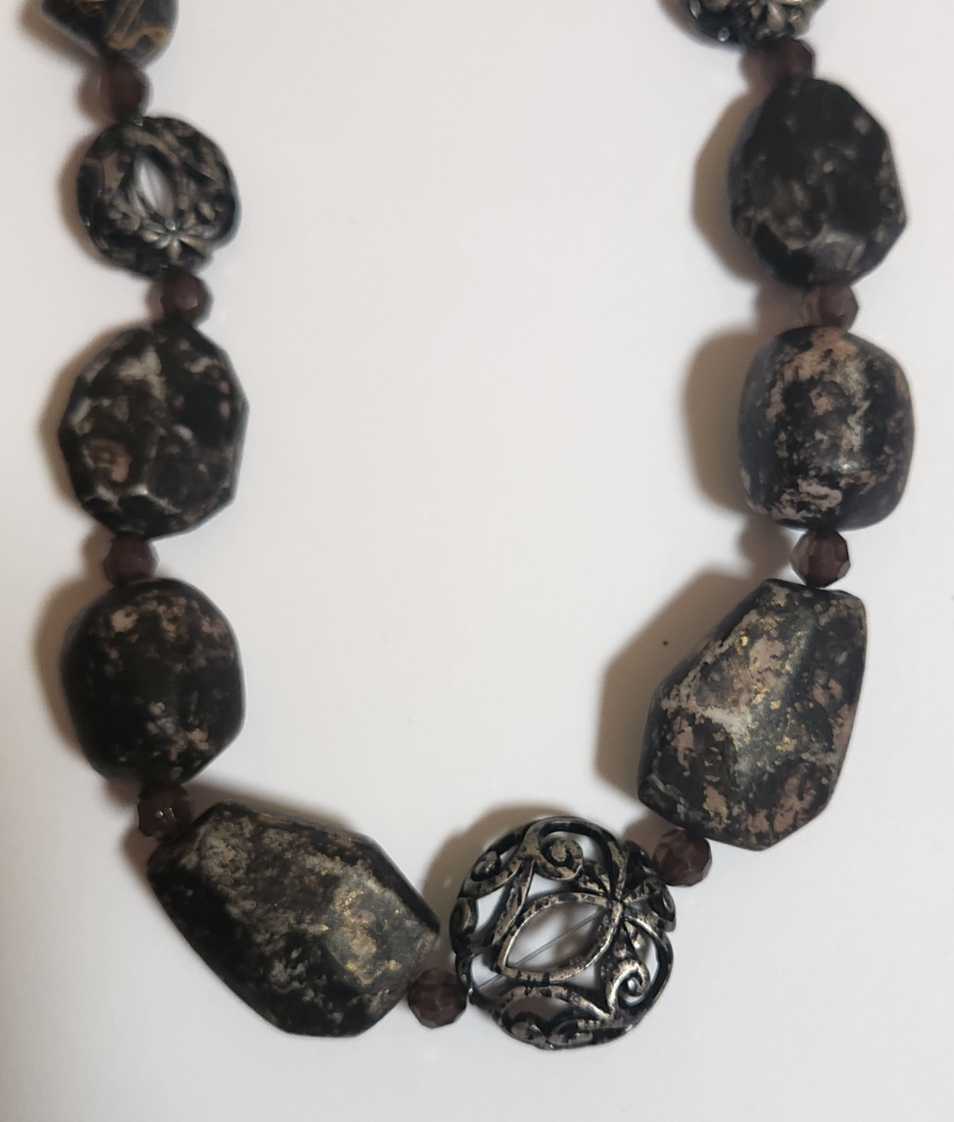 Handmade artisan necklace features chunky, speckled black beads and ornate.